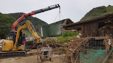 Aufbau eines Hauses mit einem Bagger 