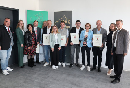 In der neuen Dienststelle in Bekond überreichten Staatssekretär Andy Becht und Weinbaupräsident Walter Clüsserath gemeinsam mit den Weinmajestäten Anna Zenz (Mosel), Hannah Roos (Mittelrhein), Annabell Stodden (Ahr) die Siegerweinkurkunden.