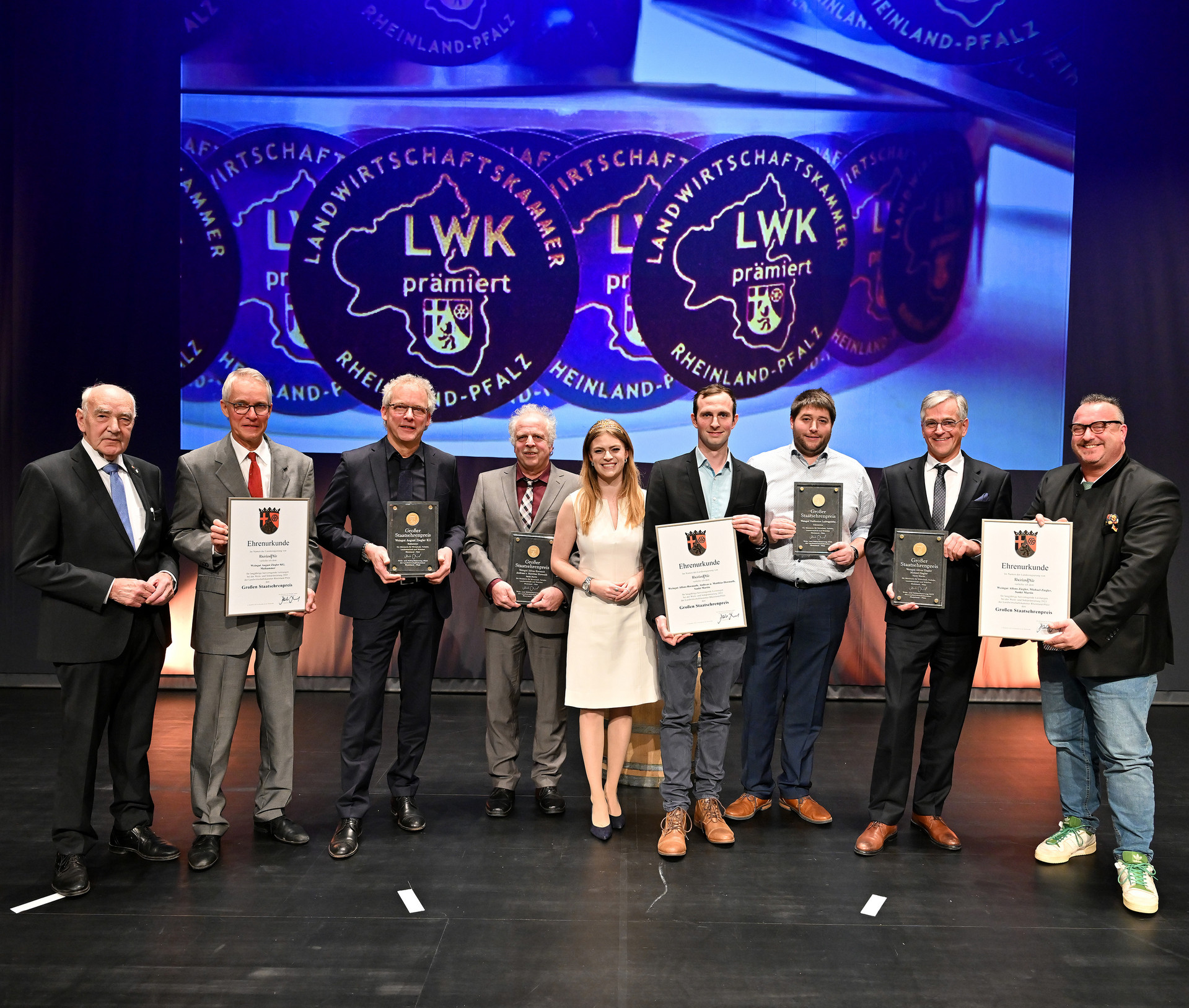 Gruppenbild mit allen drei Großen Staatsehrenpreisträgern der Pfalz (von links): Kammerpräsident Schindler, Harald und Uwe Ziegler (Weingut Ziegler aus Maikammer), Andreas Hormuth, Pfälzer Weinkönigin Charlotte Weihl, Matthias Hormuth (Weingut Alfons Hormuth aus Sankt Martin), Michael Ziegler (Weingut Alfons Ziegler aus Sankt Martin) und Staatssekretär Andy Becht.