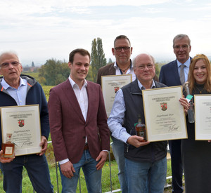 Stolz auf die Siegerbrände: Die Pfälzische Weinkönigin Denise Stripf, Lucas Mühlhäuser vom Pfälzer Brennerverband und Kammerpräsident Ökonomierat Michael Horper freuen sich mit den glücklichen Brennerinnen und Brennern.