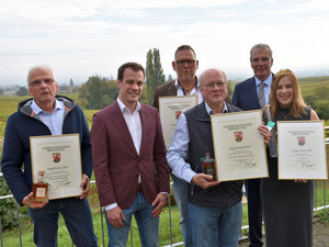 Stolz auf die Siegerbrände: Die Pfälzische Weinkönigin Denise Stripf, Lucas Mühlhäuser vom Pfälzer Brennerverband und Kammerpräsident Ökonomierat Michael Horper freuen sich mit den glücklichen Brennerinnen und Brennern.